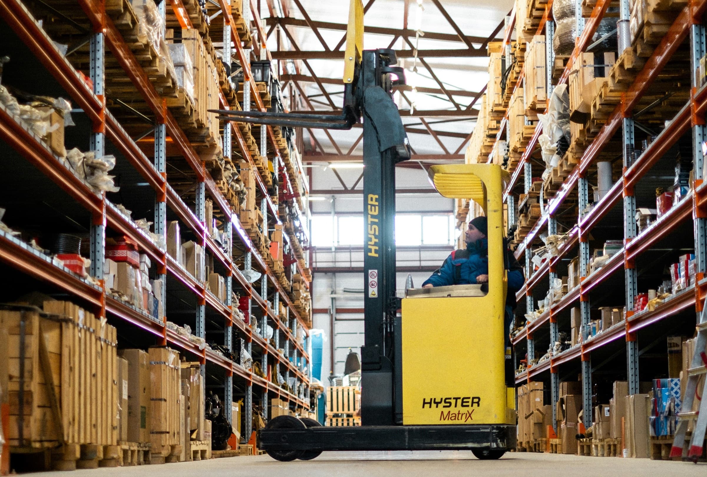 Warehouse associate operating a forklift among retail inventory