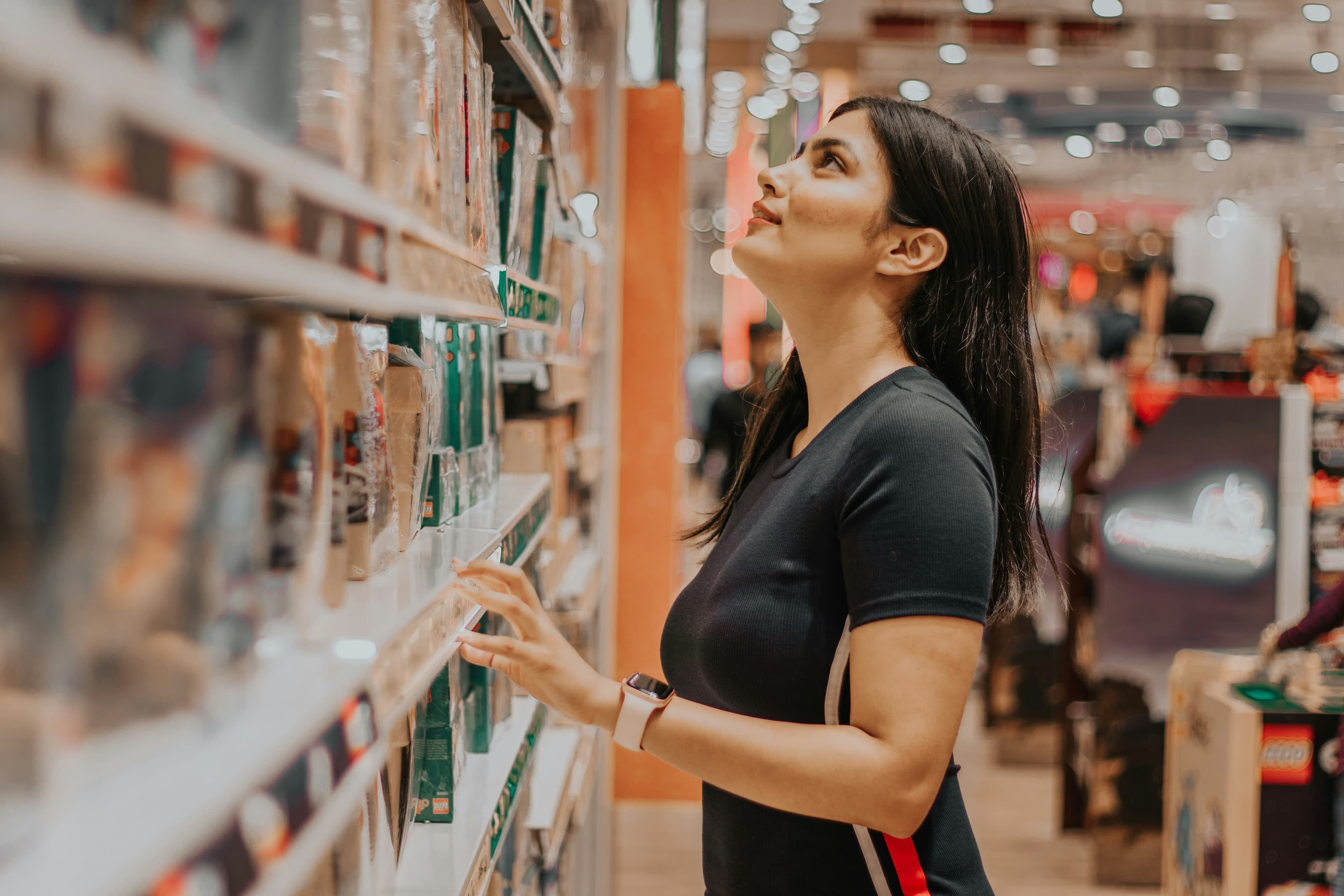Shopper browsing products on a retail shelf, representing New Nexus Group's Grow Retail services